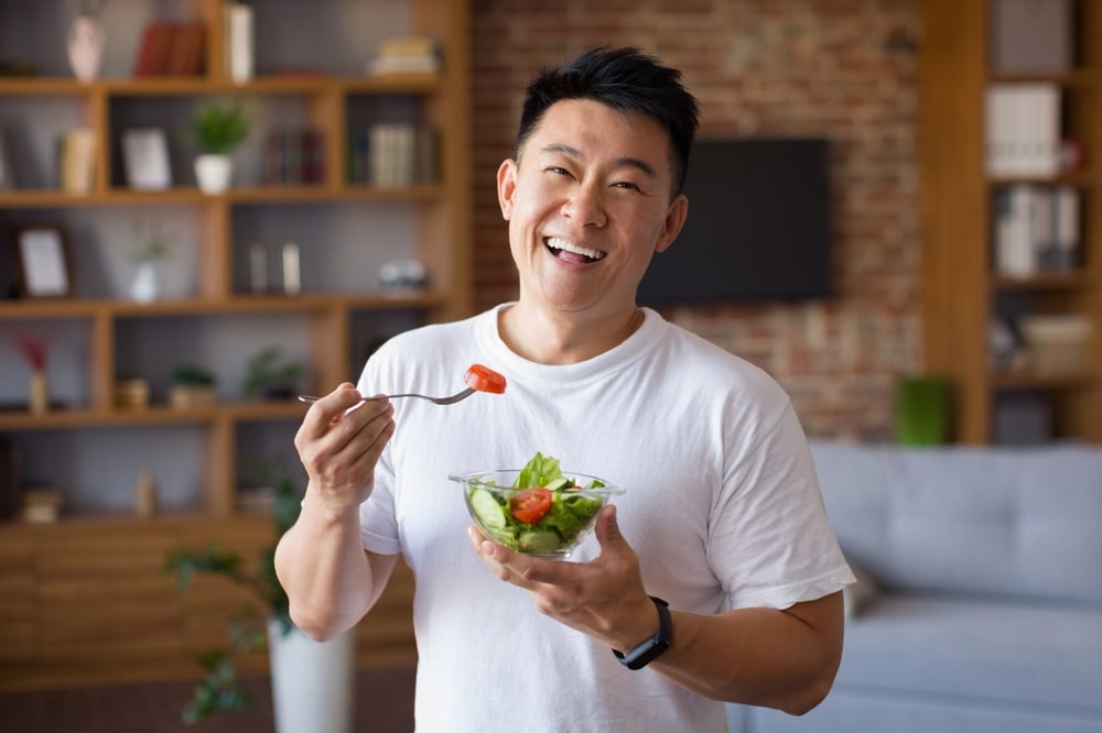 healthy man in white shirt eating meal